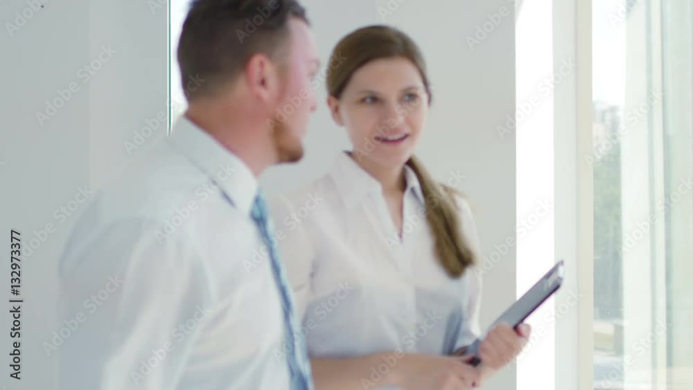 Two business people discuss passing the office Two business people discuss passing the office