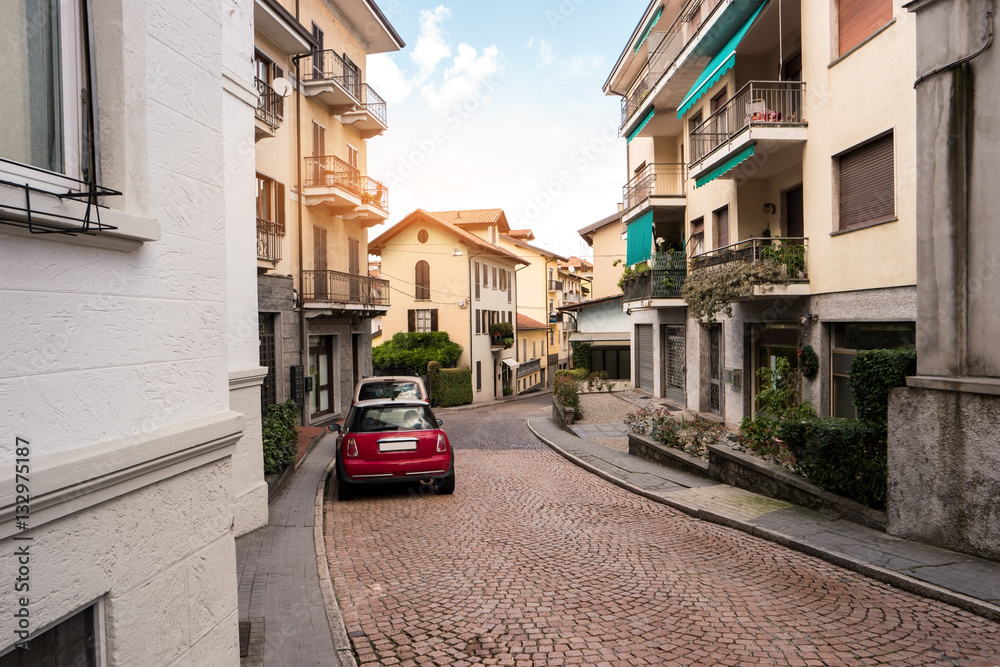 Road and town buildings. Cars parked in the street. Spend Summer in Italy.