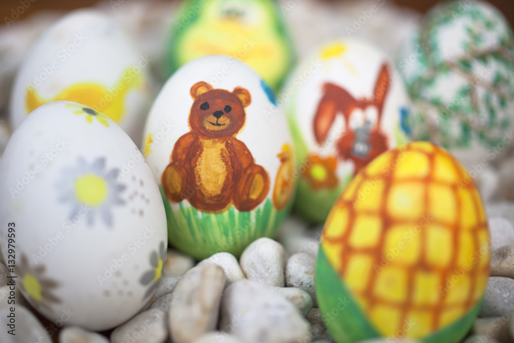 Detail of colorful blurred painted Easter eggs with different forms and animals. In that case, a bear.
