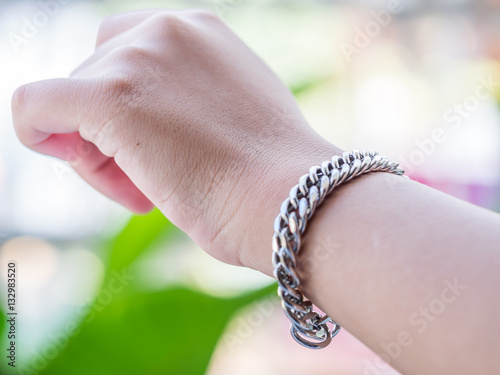 Closeup of stainless steel bracelet and girl hand