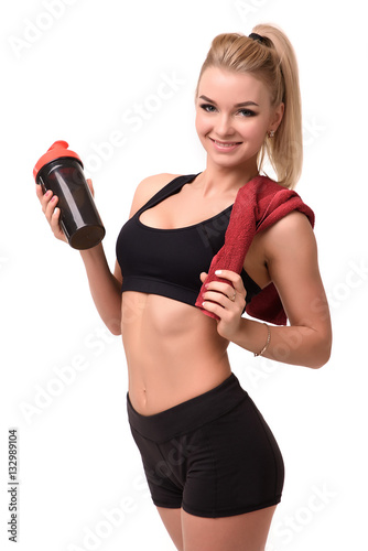 Sports happy girl after a workout holding water and towel on white background
