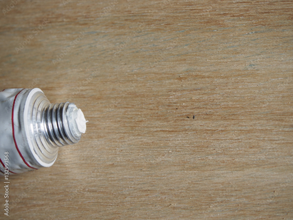 Tube of white paint on wood background Tube of white paint on wood background