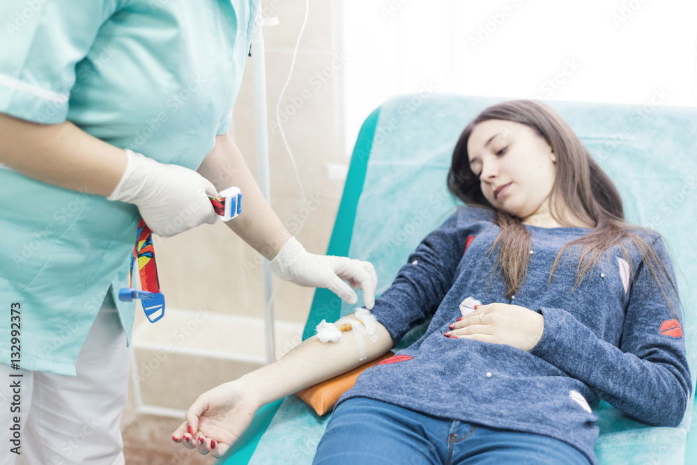 Doctor connects the dropper. patient lying bed Doctor connects the dropper. patient lying bed