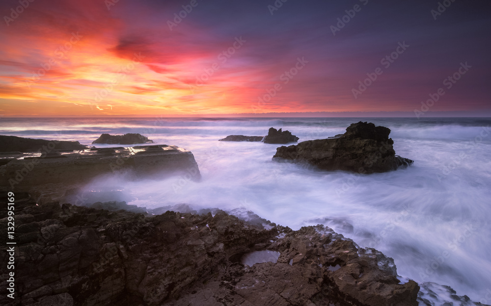 The end of a colorful day on a isolated beach, contemplating the sunset