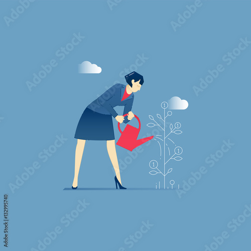 Business woman stands and waters a money tree