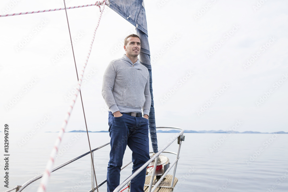 Man stands on bow of yacht day looking at sea Man stands on bow of yacht day looking at sea