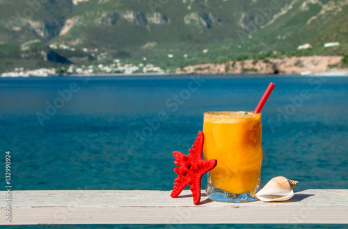 Fresh orange juice on the seaside background. photo