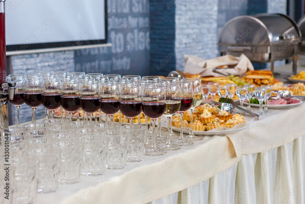 Alcoholic beverages in glasses and snacks on buffet table, catering