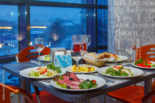 Served on a Banquet at restaurant table with dishes  snacks  Cutlery  and wine glasses. The European food.