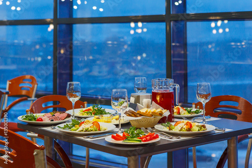 Served on a Banquet at restaurant table with dishes  snacks  Cutlery  and wine glasses. The European food.