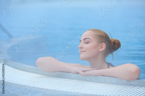 Young woman in outside thermal pool, relaxed