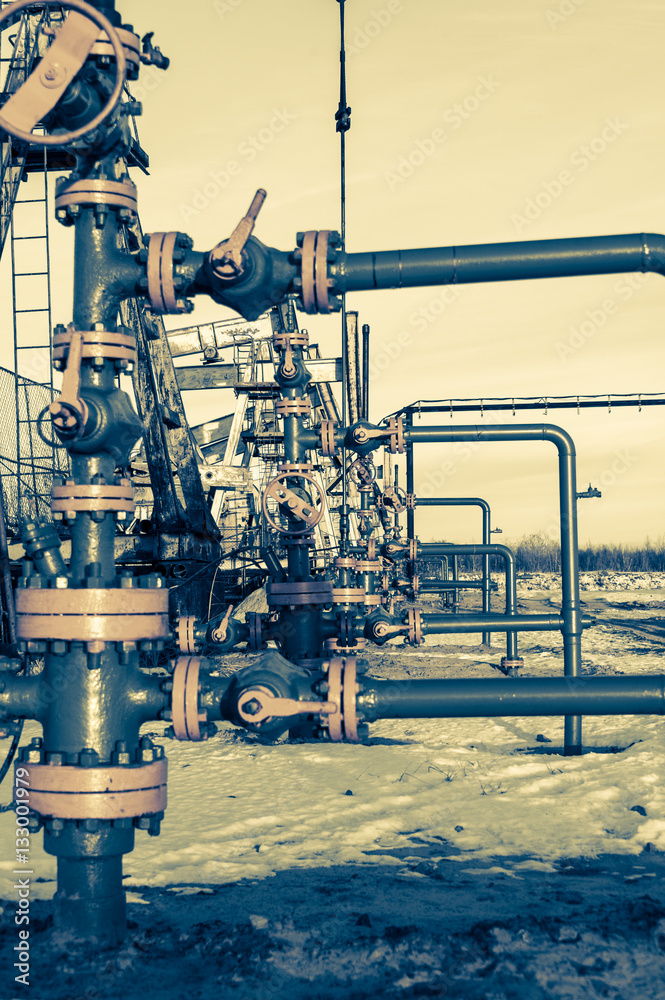 Group of wellhead. Oilfield with sand ground. Oil and gas . Toned.