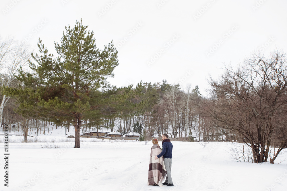 Stylish beautiful young couple bride and groom on the background of a winter landscape