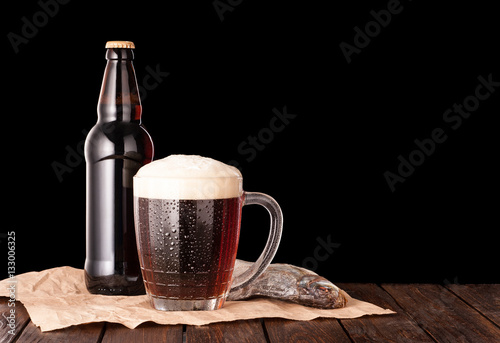 dark cold beer in a frosty mug, stockfish, brown bottle on dark