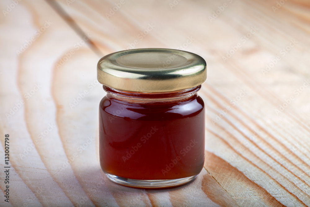 a jar of Maroon jam on a wooden table a jar of Maroon jam on a wooden table