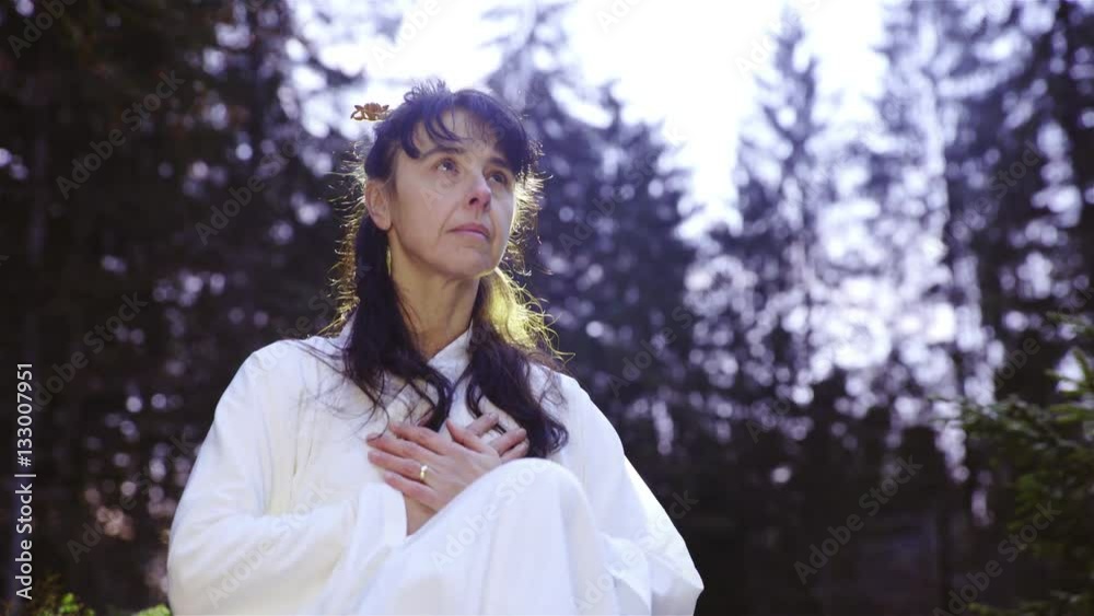 Woman in nature meditate while holding own chest 4K
Woman in nature meditate while holding own chest 4K