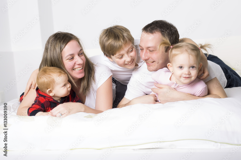 five member Young Family Having Fun In Bed