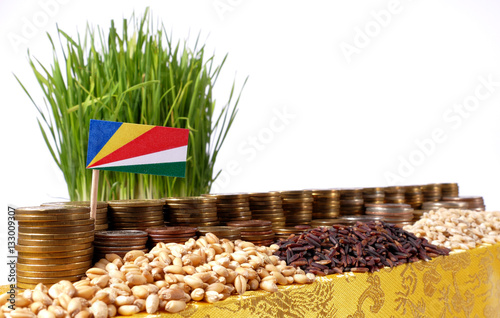 Seychelles flag waving with stack of money coins and piles of wheat