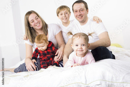 Bild auf Leinwand five member Young Family Having Fun In Bed