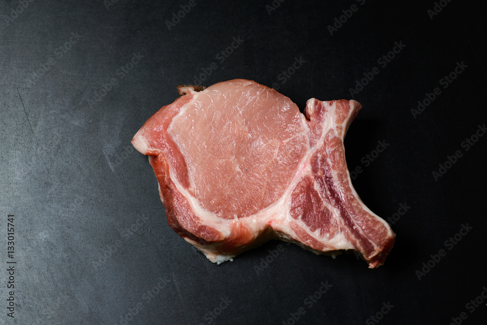 Top view raw pork chop steak and garlic, pepper, salt on wooden background. Top view raw pork chop steak and garlic, pepper, salt on wooden background.