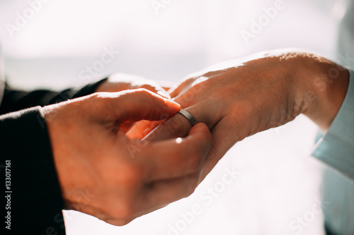 Male hands putting ring on finger of woman © Mangostar
