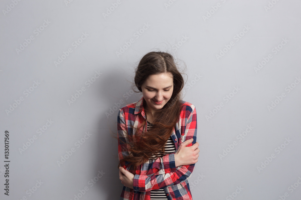 Girl freezes from the cold, hugging her arms. Embarrassed and looking at the floor Girl freezes from the cold, hugging her arms. Embarrassed and looking at the floor