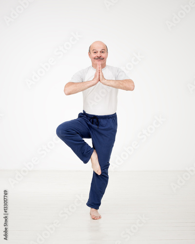 Elderly man practicing yoga or fitness. Positive mood on sports