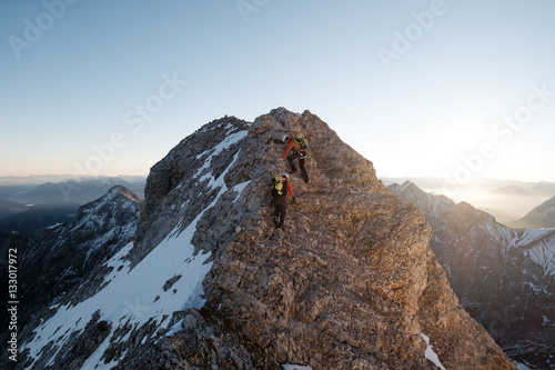 Two mountaineers climbing on mountain peak in European Alps