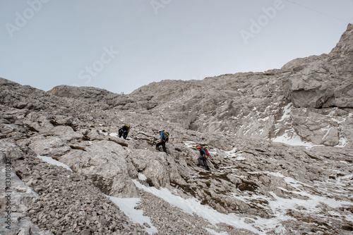 Group of mountaineers hiking on trail in mountain range
