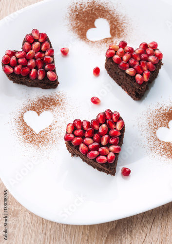 Heart shaped Valentines day cake with pomegranate seeds on white plate - Valentines day dessert, love concept