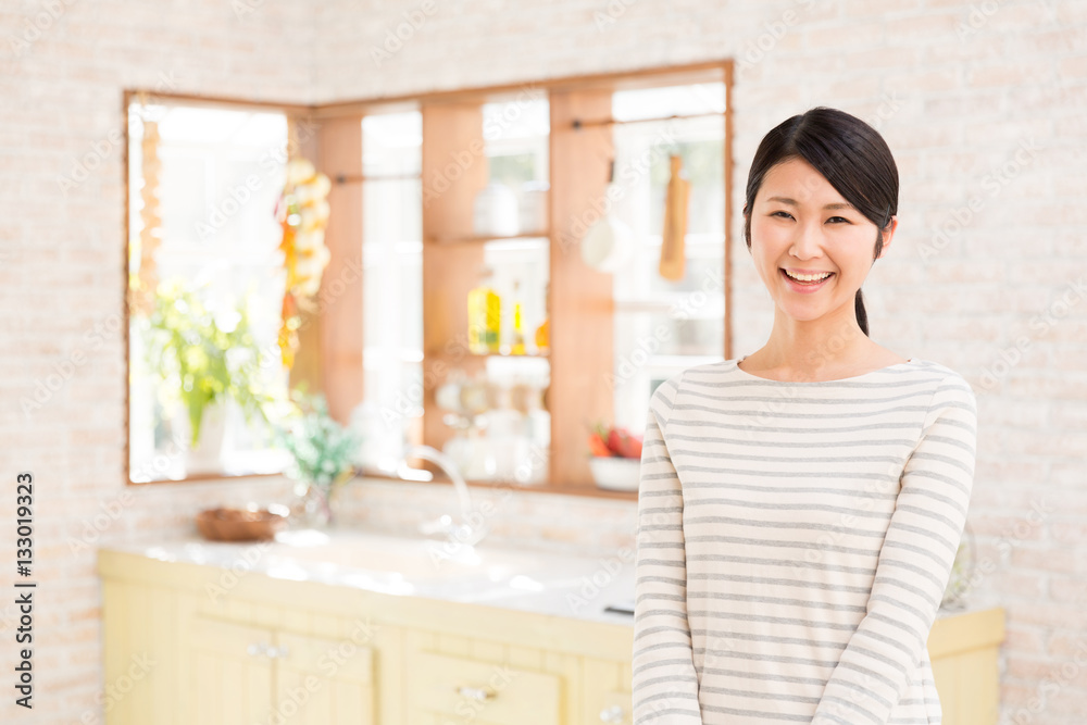 portrait of young asian woman relaxing in the kitchen