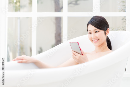 young asian woman relaxing in bathtub