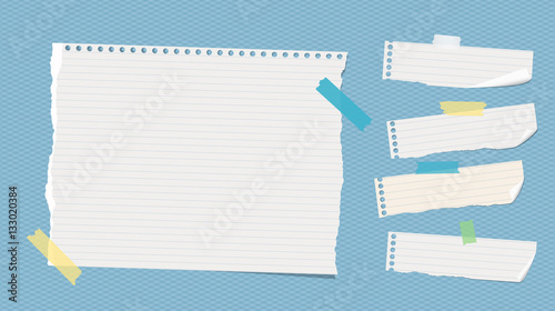 Ripped white ruled note, notebook, copybook paper sheets stuck with colorful sticky tape on blue squared pattern
