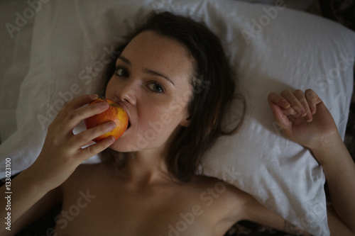 Innocent creative girl eats apple (concept for sexual transgress photo