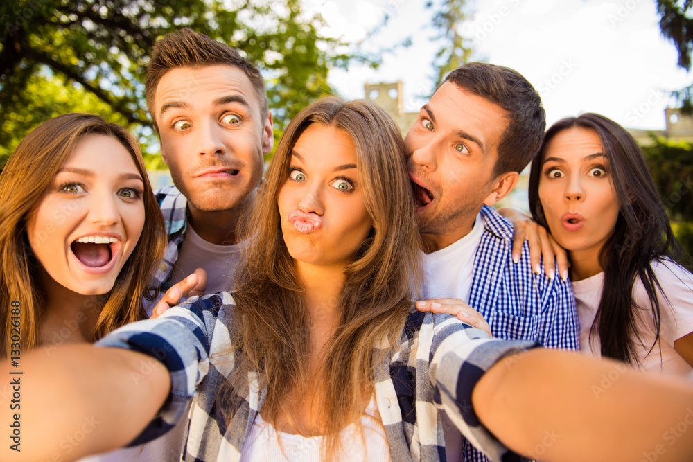 five cheerful fooling best friends making selfie photo and havin