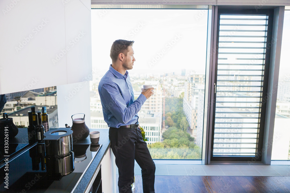 Businessman in apartment having a coffee break Businessman in apartment having a coffee break