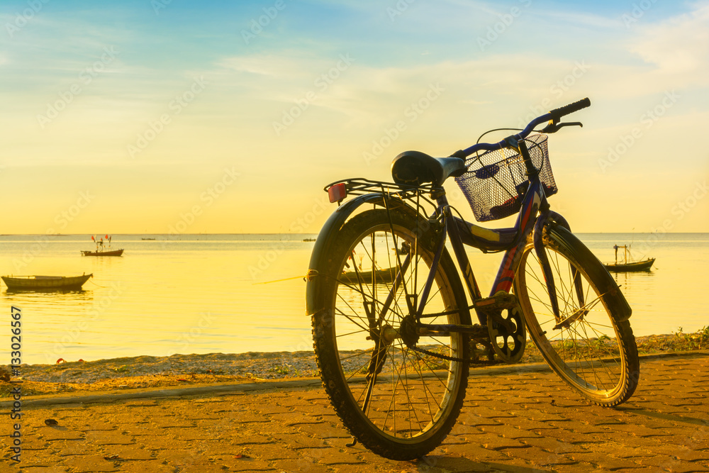 Ride a bicycle on beach with warm light background Ride a bicycle on beach with warm light background