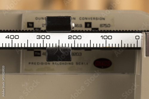 Macro Image of an Old Balance Scale - 250 Grains indicated on scale - photographed on an antique maple table in the Vertical orientation