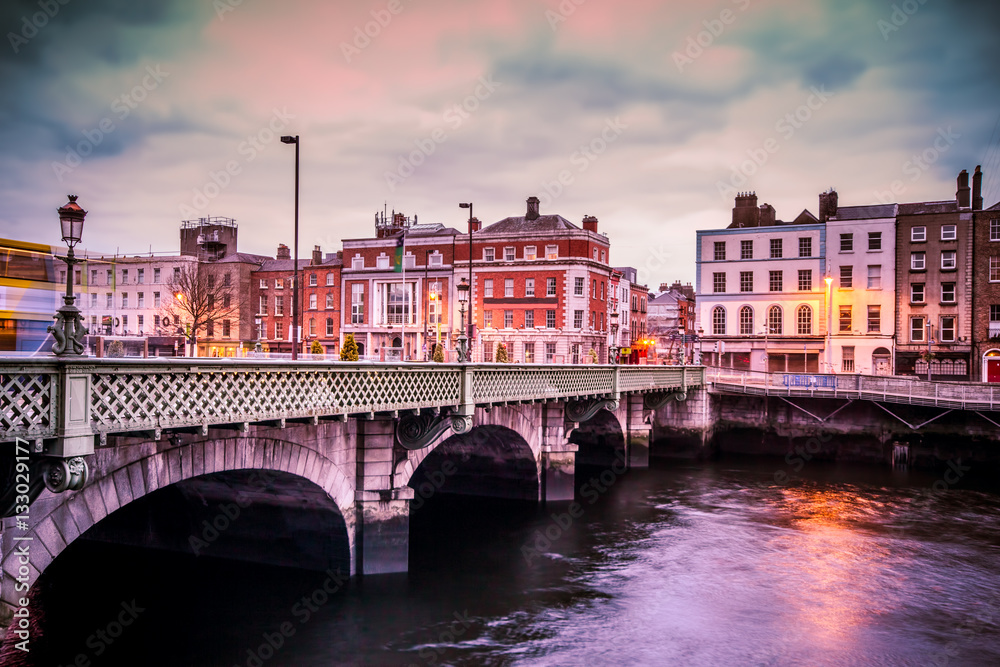 Fototapeta premium Historyczny most Grattan nad rzeką Liffey w Dublinie w Irlandii o zachodzie słońca
