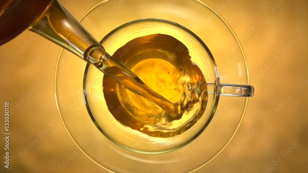 Green tea. Pouring tea into a glass cup. Slow motion 240 fps. High speed camera shot.