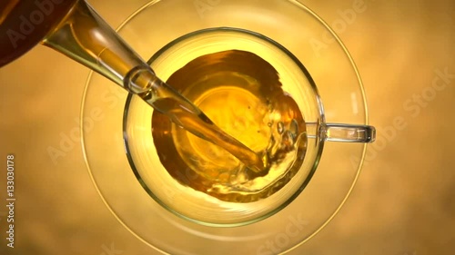 Green tea. Pouring tea into a glass cup. Slow motion 240 fps. High speed camera shot.