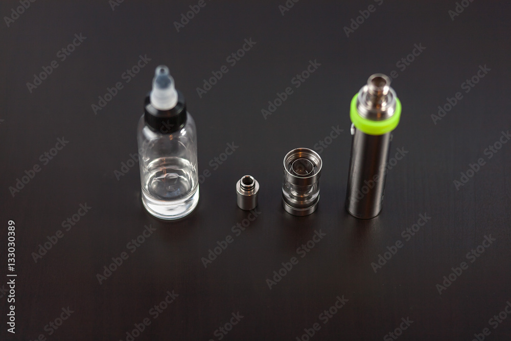 Parts of e-cigarette and a jar with fluid for personal vaporisers. Electronic nicotine delivery systems (ENDS). Jar with fluid. Parts of e-cigarette and a jar with fluid for personal vaporisers. Electronic nicotine delivery systems (ENDS). Jar with fluid.