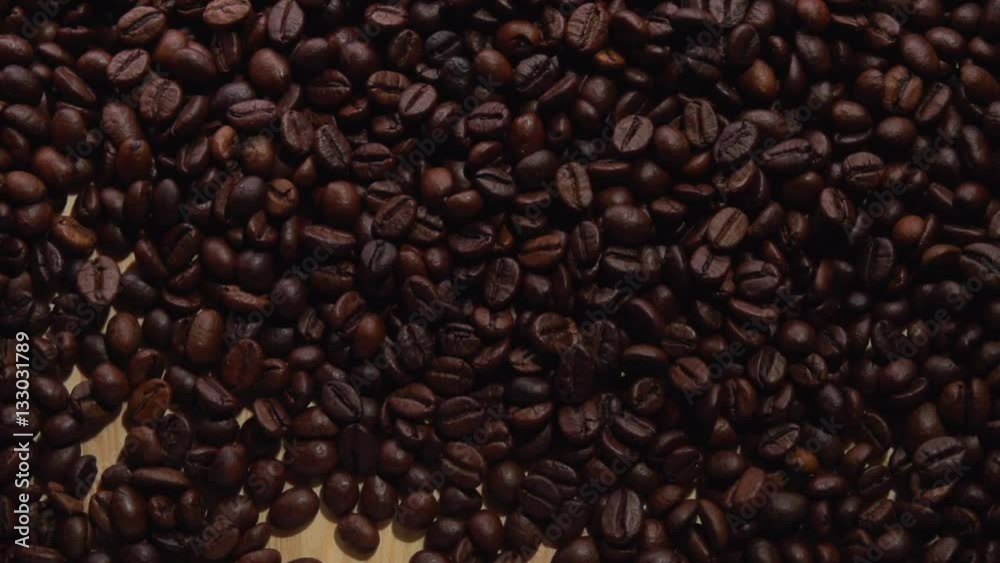 Coffee beans on a wooden table. Background of falling coffee beans. Slow motion 240 fps Coffee beans on a wooden table. Background of falling coffee beans. Slow motion 240 fps