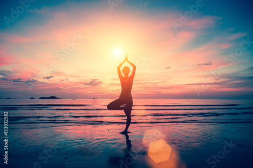 Silhouette yoga girl on the background of stunning sea and sunset. Fitness, meditation and healthy lifestyle.