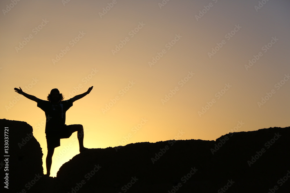 Felicidad y triunfo en hombre con brazos abiertos a contraluz Felicidad y triunfo en hombre con brazos abiertos a contraluz