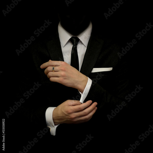 Картината върху платно Man in a black suit and white shirt and black tie on a black background