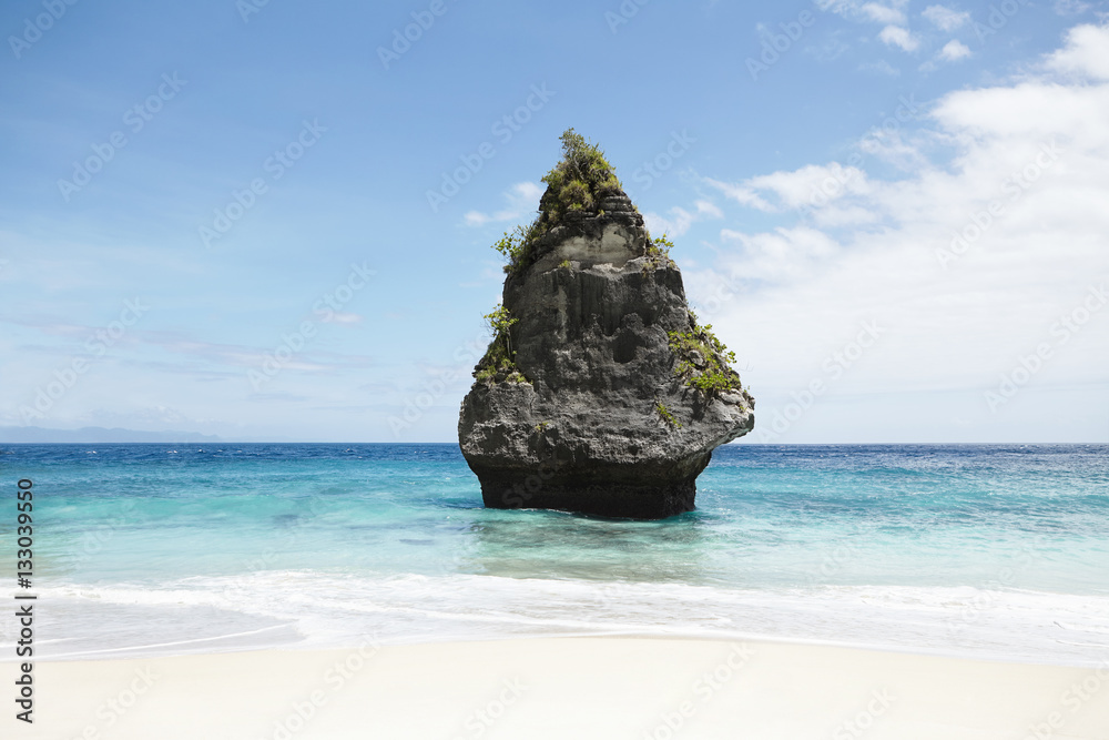 Ideal and peaceful seascape: blue sky, stone island with vegetation in  middle of ocean with turquoise water. Perfect place for adventurer  somewhere at deserted beach with copy space for your text Stock