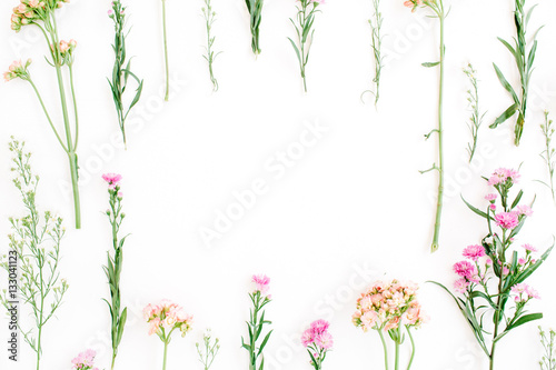 Frame with colorful wildflowers  green leaves  branches on white background. Flat lay  top view. Valentine s background