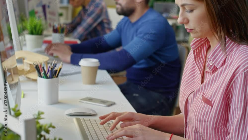 Tilt down of concentrated startup workers sitting in office and working on computers Tilt down of concentrated startup workers sitting in office and working on computers