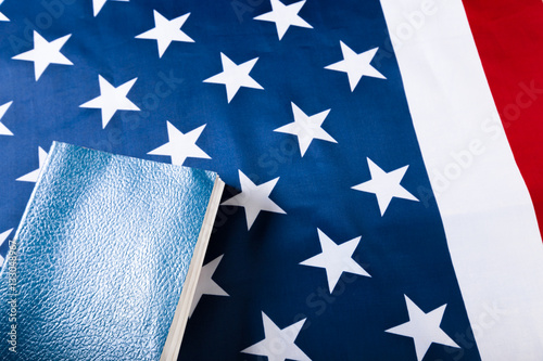 Fototapeta Naklejka Na Ścianę i Meble -  Bible laying on top of an american flag